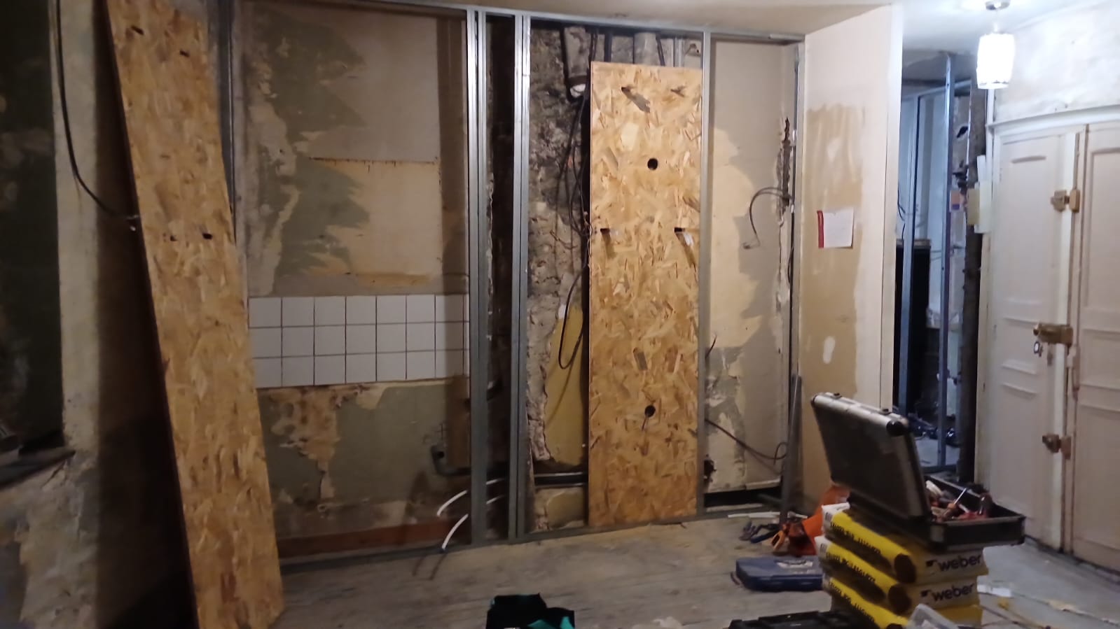 Salle de bain en cours de rénovation — ossature métallique et dépose de l'ancien revêtement