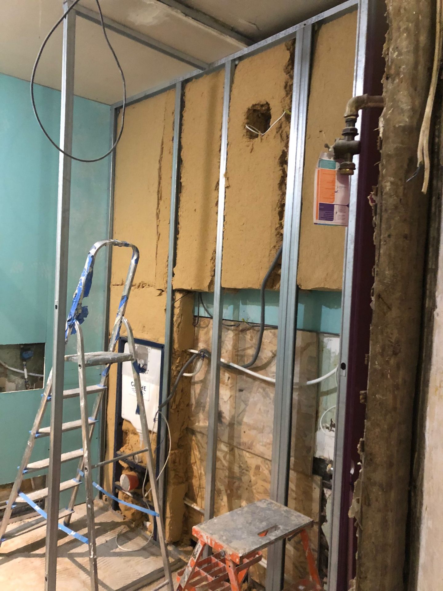 Salle de bain en cours : ossature métallique posée et réseaux passés