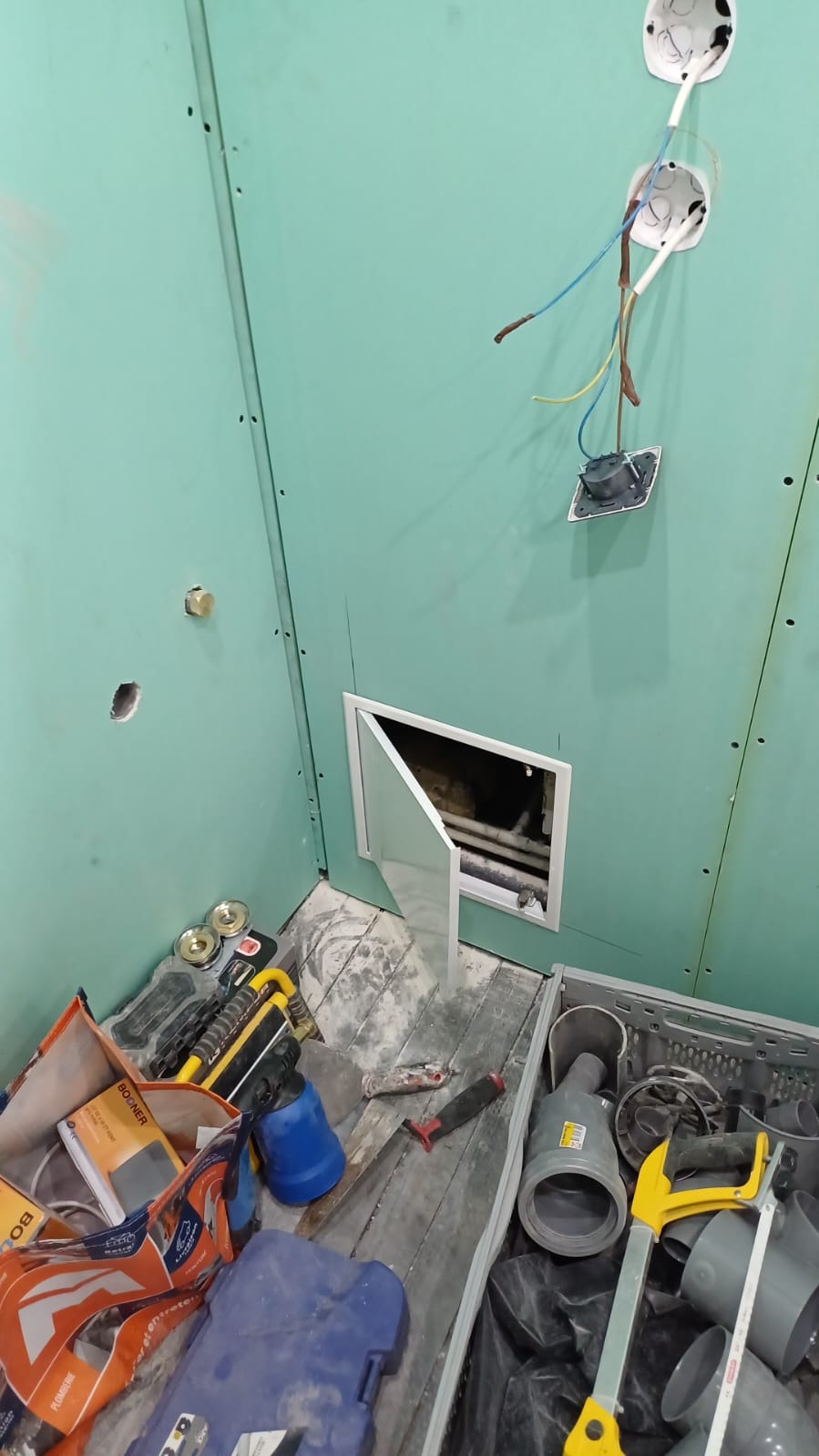 Cloison placo hydrofuge (vert) préparée pour la salle de bain — évacuations PVC en attente